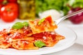 Ravioli pasta meal from Italy for lunch dish with fork and tomato sauce on a plate Royalty Free Stock Photo