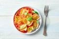 Ravioli with tomato sauce and fresh basil leaves on a plate, overhead Royalty Free Stock Photo