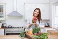 Ravishing radishes. A gorgeous woman holding up a bunch of radishes while standing behind a basket of fresh vegetables Royalty Free Stock Photo