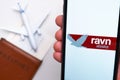 Ravn alaska Airline logo on the mobile phone screen with a plane, passport and boarding pass on the background. The