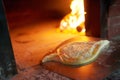 Raw Ajarian khachapuri cooked in an oven with burning firewood.