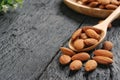Raw Almonds on wooden spoon placed on black wooden plank, copy space concept. Royalty Free Stock Photo