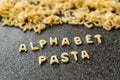 Raw Alphabet Pasta is Written with Letters on Granit Grey Surface. Royalty Free Stock Photo