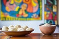 raw arepa dough balls next to a bowl of masa