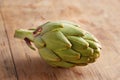 Raw artichoke on wooden table