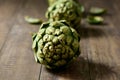 Raw artichokes on a wooden surface Royalty Free Stock Photo