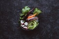 Raw asian bowl with rice noodles, carrot, radish and cucumber on black background. Top view. Royalty Free Stock Photo