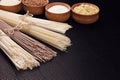 Raw asian noodles with ingredient in wooden bowls on black striped mat background with copy space. Royalty Free Stock Photo