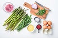 Raw asparagus eggs and french dressing ingredients with dijon mustard, onion chopped in red vinegar  taragon on white textured Royalty Free Stock Photo