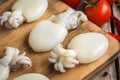 Raw babies cuttlefish on a cutting board with tomatoes Royalty Free Stock Photo