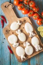 Raw babies cuttlefish on a cutting board with tomatoes Royalty Free Stock Photo