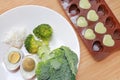 Raw of baby food broccoli, egg and rice in white plate and mashed baby food in container for freezing on wooden board Royalty Free Stock Photo