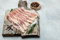 Raw bacon, bacon strips meat slice thin slicing pork fat meal on a light background, ketogenic diet, place for text, top view