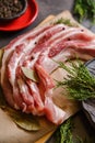 Raw bacon pork for preparing a dinner for a Christmas holiday dishes on a dark table with a Christmas decorations