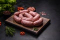 Raw barbecue sausages on a wooden cutting board with spices and herbs Royalty Free Stock Photo