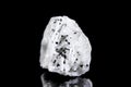 Raw barite or barium mineral stone with tourmaline or schorl in front of black background
