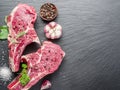 Raw beaf steaks with spices on the cutting board. Royalty Free Stock Photo