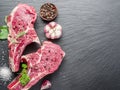 Raw beaf steaks with spices on the cutting board.