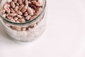 Raw beans in a glass jar on a white table background. Top view. Copy, empty space for text Royalty Free Stock Photo