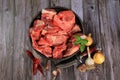 Raw beef bones in round clay bowl on wooden table decorated with vegetables and spices, vintage hunter knife. Beef selection for b Royalty Free Stock Photo