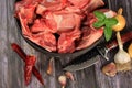 Raw beef bones in round clay bowl on wooden table decorated with vegetables and spices, vintage hunter knife. Beef selection for b Royalty Free Stock Photo