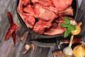 Raw beef bones in round clay bowl on wooden table decorated with vegetables and spices, vintage hunter knife. Beef selection for b Royalty Free Stock Photo