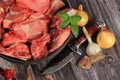 Raw beef bones in round clay bowl on wooden table decorated with vegetables and spices, vintage hunter knife. Beef selection for b Royalty Free Stock Photo