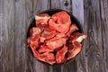 Raw beef bones in round clay bowl on wooden table