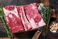 Raw beef calf short ribs meat on a butcher cutting board with cleaver. Dark wooden background. Top view Royalty Free Stock Photo