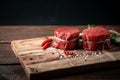 Raw beef filet Mignon steak on a wooden Board with pepper and salt Royalty Free Stock Photo