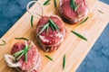 Raw beef filet mignon steak on a wooden board with rosemary and spices Royalty Free Stock Photo