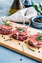 Raw beef filet mignon steak on a wooden board with rosemary and spices Royalty Free Stock Photo