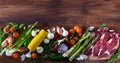 Raw beef with fresh vegetables on wooden background Royalty Free Stock Photo