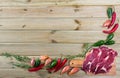 Raw beef with fresh vegetables on wooden background Royalty Free Stock Photo