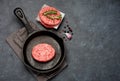 Raw Beef Meat Burger cutlets and spices in a cast-iron frying pan. Royalty Free Stock Photo