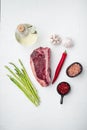 Raw beef meat Club or striploin on the bone steak with ingredients, on white stone  background, top view flat lay, with copy space Royalty Free Stock Photo