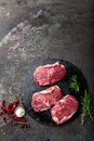 Raw beef meat. Fresh steaks on slate board on black background