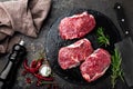 Raw beef meat. Fresh steaks on slate board on black background Royalty Free Stock Photo