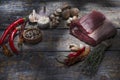 Raw beef meat with species, chili pepper, salt, tyme, garlic on a wooden board, background.