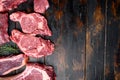 Raw beef meat steaks, tomahawk, t bone, club steak, rib eye and tenderloin cuts, on old dark  wooden table background, top view Royalty Free Stock Photo