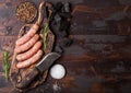 Raw beef and pork sausage on old chopping board with vintage knife on dark wooden background.Salt and pepper with rosemary.Space Royalty Free Stock Photo