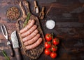 Raw beef and pork sausage on old chopping board with vintage knife and fork on dark wooden background.Salt and pepper with Royalty Free Stock Photo