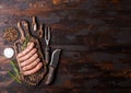 Raw beef and pork sausage on old chopping board with vintage knife and fork on dark wooden background.Salt and pepper with Royalty Free Stock Photo