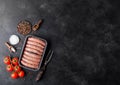 Raw beef and pork sausage in plastic tray with vintage fork on black background.Salt and pepper with tomatoes and rosemary.Space Royalty Free Stock Photo