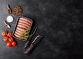Raw beef and pork sausage in plastic tray with vintage knife and fork on black background.Salt and pepper with tomatoes and Royalty Free Stock Photo