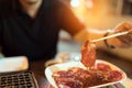 Raw beef or pork slice for charcoal grill, Yakiniku Japanese style barbecue, man using chopsticks, street food concept Royalty Free Stock Photo