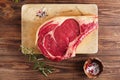 Raw beef Rib bone steak on wooden board and table Royalty Free Stock Photo