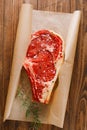 Raw beef Rib steak with bone in paper on wooden Royalty Free Stock Photo