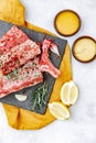Raw beef ribs, fresh meat with mustard sauce and lemon, top view, Royalty Free Stock Photo