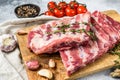 Raw beef ribs with rosemary, pepper and garlic. Gray background. Top view